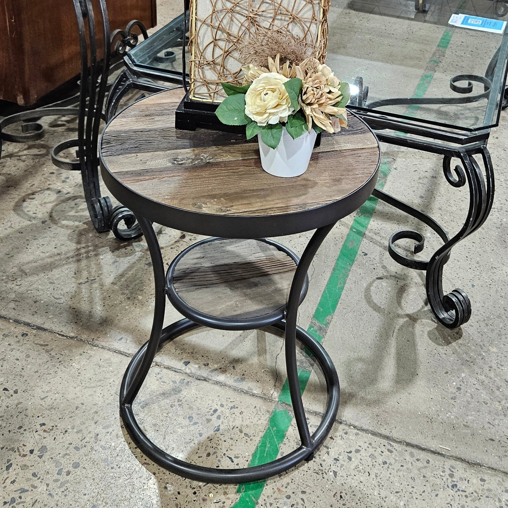 Glass dining table with black metal frame on a concrete floor