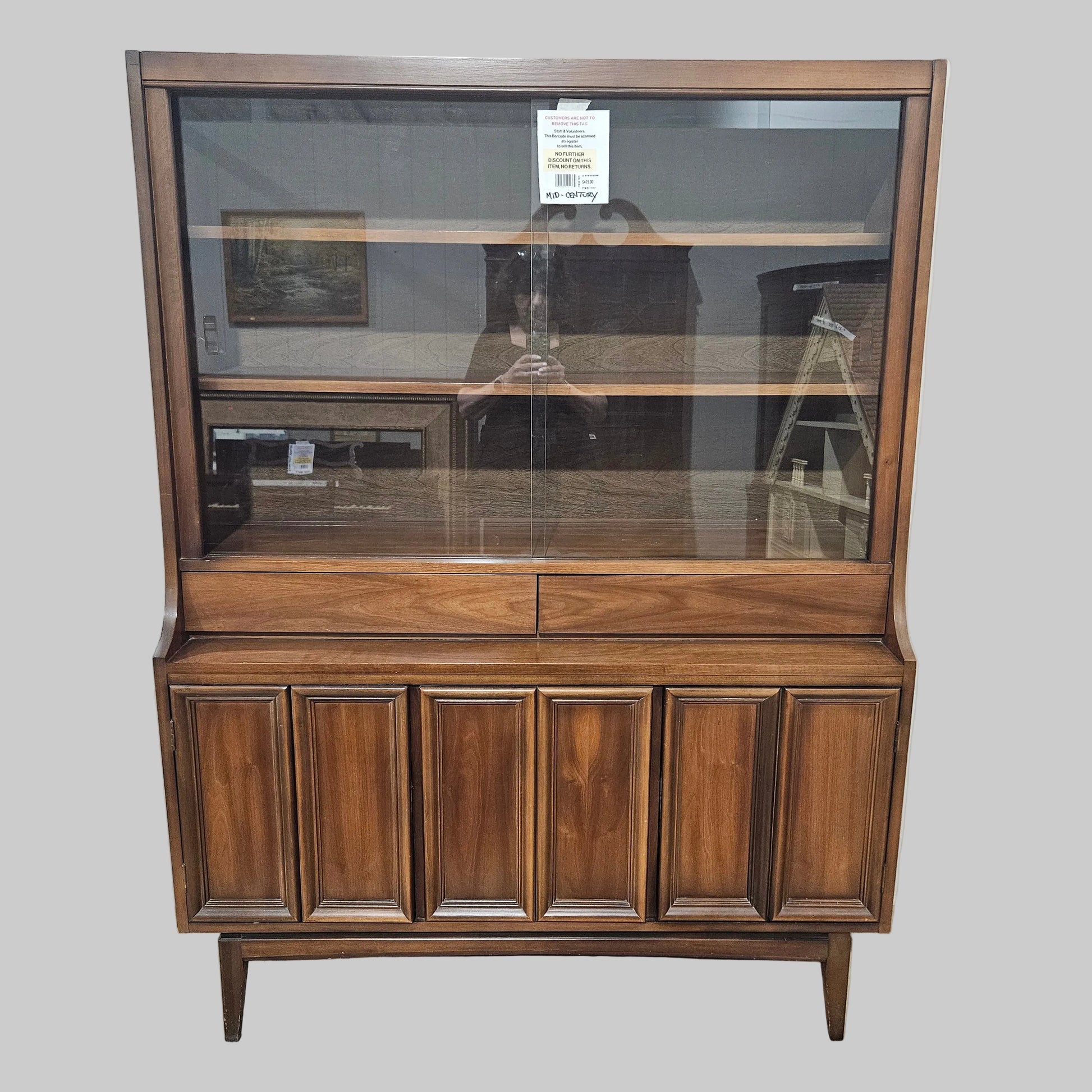 Wooden cabinet with glass panel on a white wall