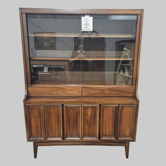 Wooden cabinet with glass panel on a white wall