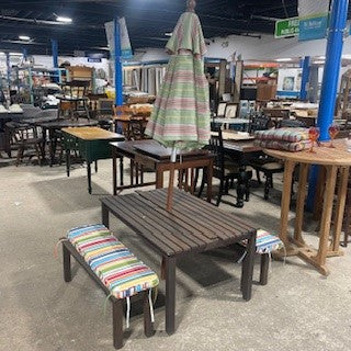 Picnic table with umbrella, benches, and cushions